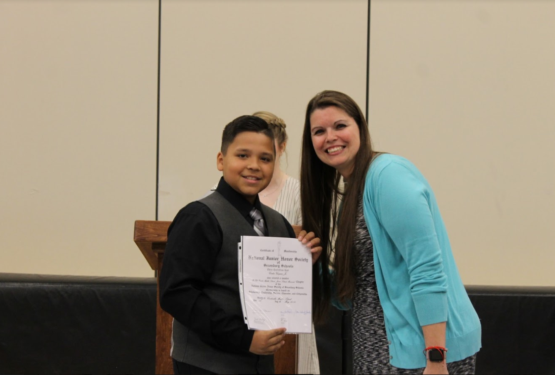 National Junior Honor Society inductee Carlos Vazquez receives his certificate from chapter advisor Mrs. Lisa Powers.