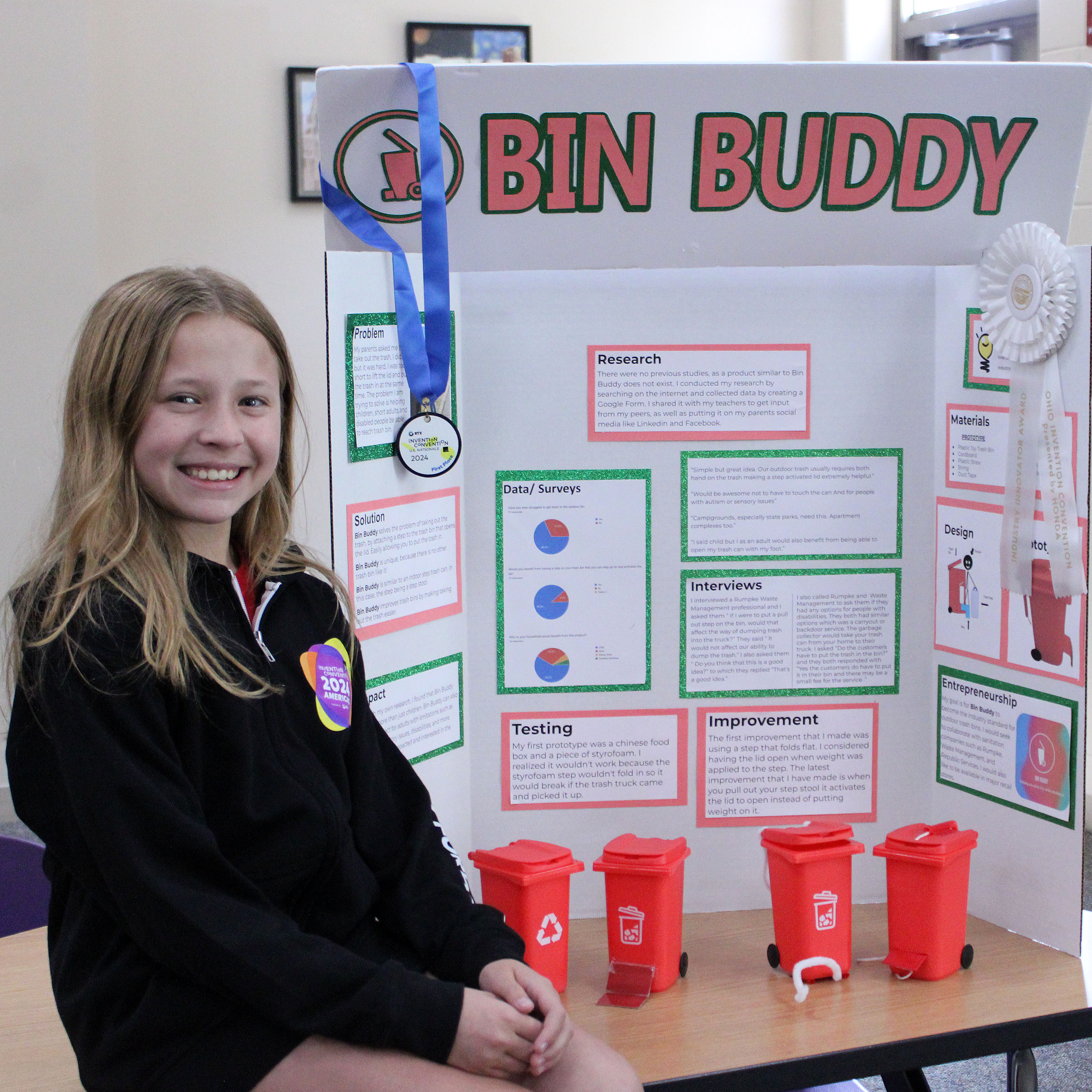 Bright Conde sits with her project board and replica Bin Buddies