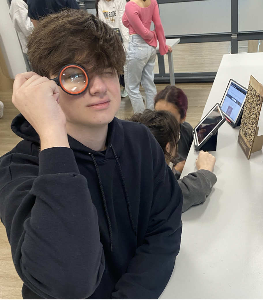 Student looking through a magnifying glass