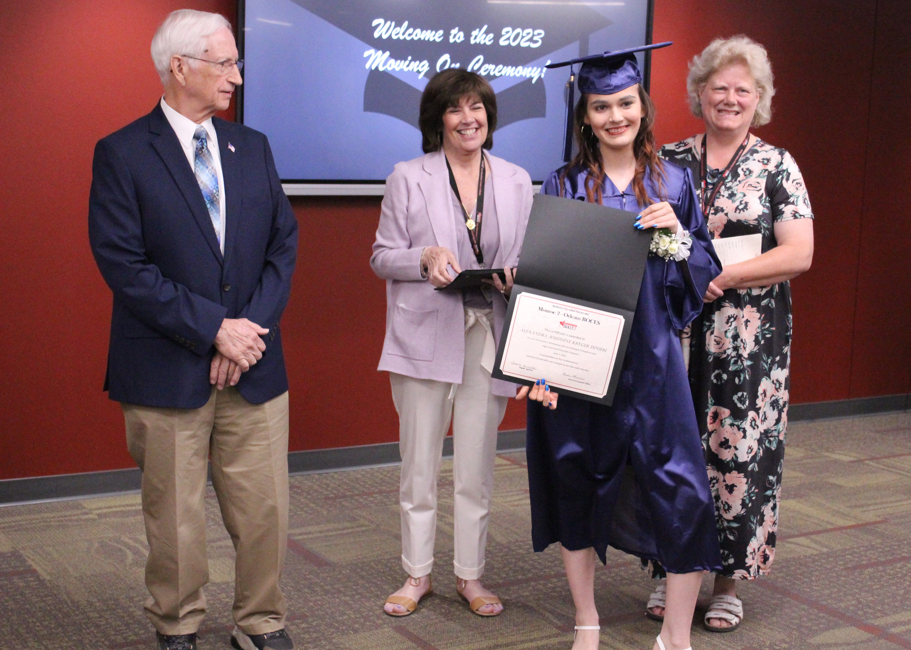 Student with administrators holding her certificate