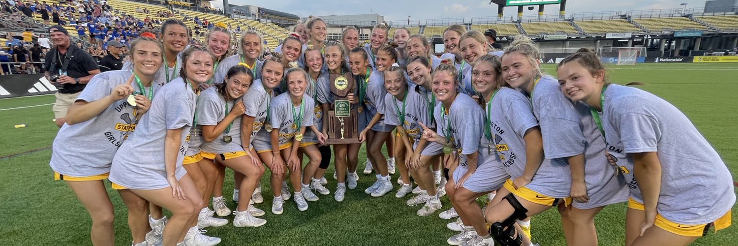 The girls lacrosse team posing for a photo with their state championship trophy