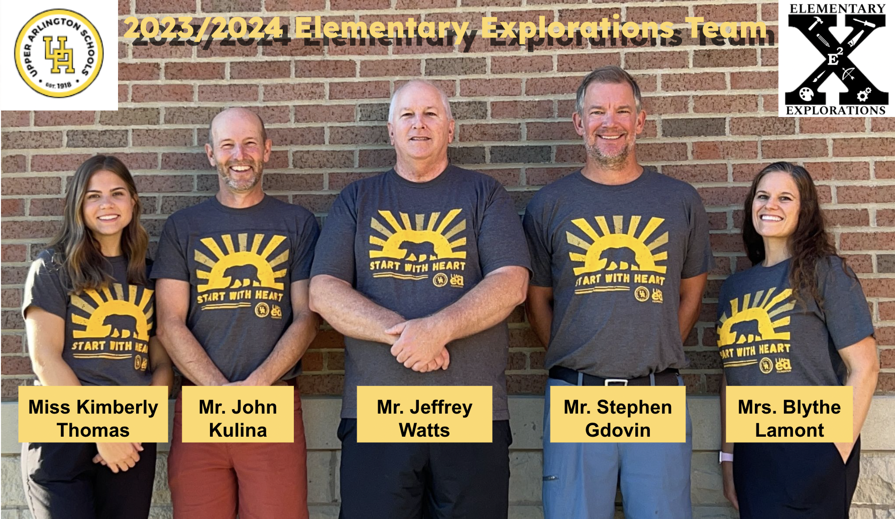 The five members of the Elementary Explorations team posing for a photo in front of a brick wall, all wearing their staff gray and gold Start With Heart t-shirts