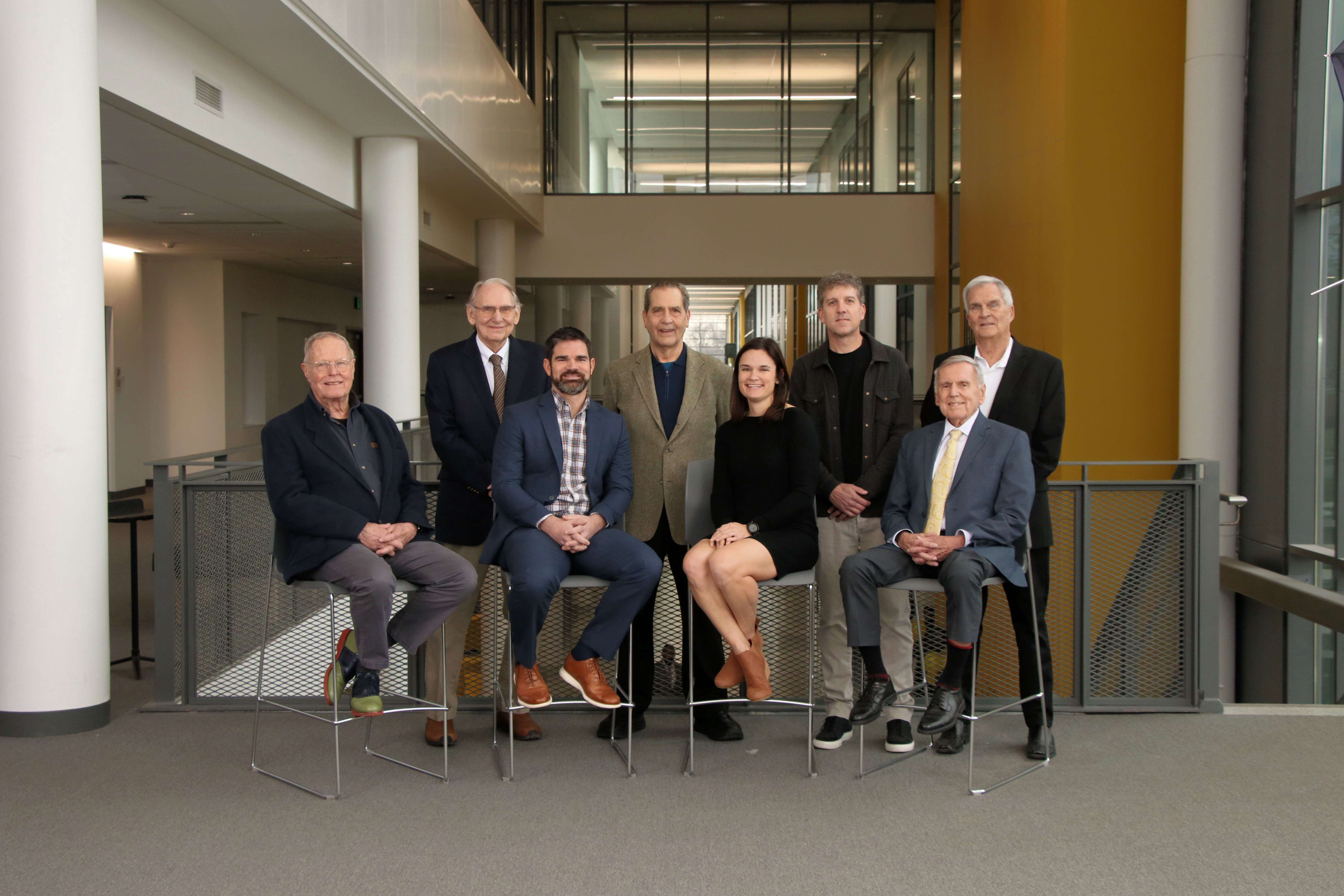 Eight inductees to the Upper Arlington High School Athletic Hall of Fame in 2023 - seated and standing overlooking Golden Bear Boulevard in the high school